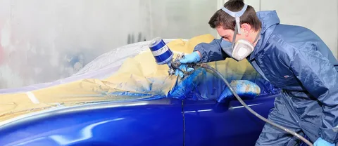 Professional car paint spray booth showing primer and base coat application