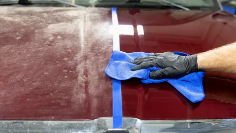 Applying scratch remover with microfiber cloth for DIY car paint repair