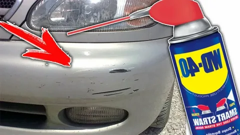 WD-40 on car paint being sprayed on a car bumper to remove tar residue